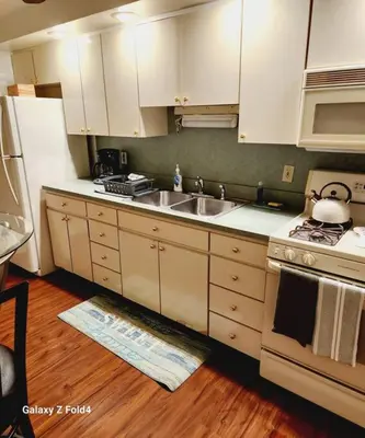 a kitchen with white cabinets and a sink and a stove at Cozy 1 Bedroom Business Suite in Philadelphia