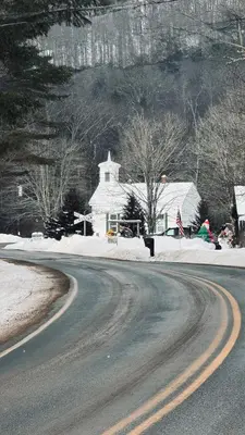 a road in front of a white house in the snow at The Tannery House in Claryville