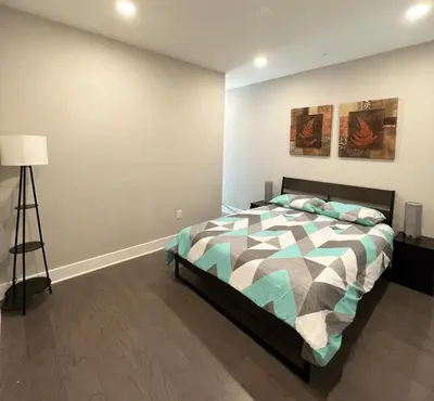 a bedroom with a bed and a lamp in it at Modern 2BR 2BA Apartment with rooftop in Brewerytown in Philadelphia