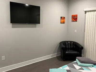 a living room with a black chair and a flat screen tv at Modern 2BR 2BA Apartment with rooftop in Brewerytown in Philadelphia