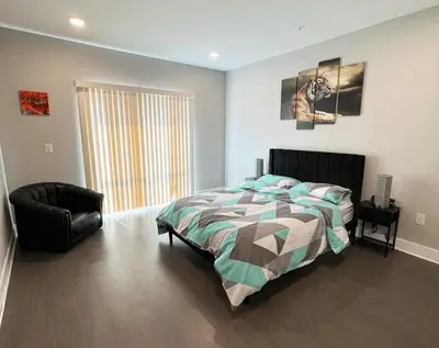 a bedroom with a bed and a chair at Modern 2BR 2BA Apartment with rooftop in Brewerytown in Philadelphia