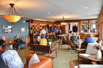 a group of people sitting in a restaurant at Chestnut Inn at Oquaga Lake in Deposit