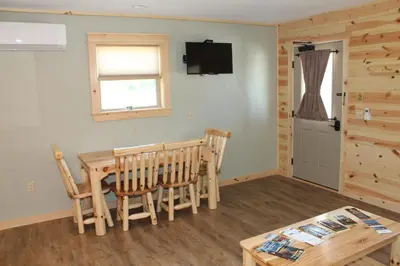 a dining room with a table and chairs and a television at Vista Lodge Benton PA near Ricketts Glen State Park in Benton