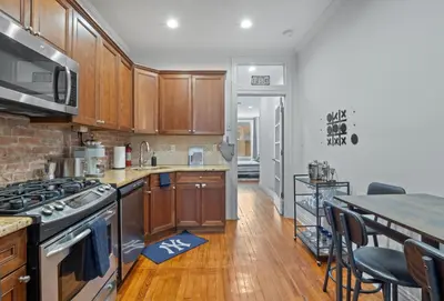 a kitchen with wooden cabinets and a stove top oven at Large Home - Great Location - 15 Minutes to NYC in Hoboken