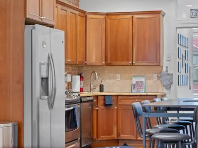 a kitchen with wooden cabinets and a white refrigerator at Large Home - Great Location - 15 Minutes to NYC in Hoboken