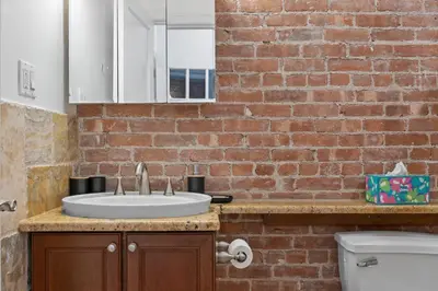 a bathroom with a sink and a brick wall at Large Home - Great Location - 15 Minutes to NYC in Hoboken