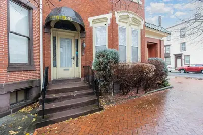 a brick house with a white door and stairs at Stylish Private 2 Bed Apt in Harrisburg
