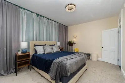 a bedroom with a bed with a blue comforter at Stylish Private 2 Bed Apt in Harrisburg