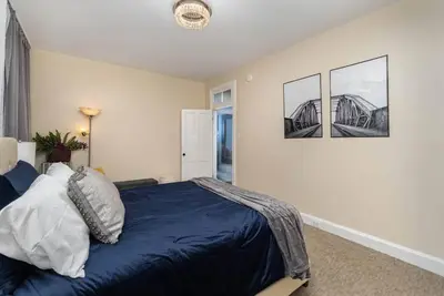 a bedroom with a blue bed with two pictures on the wall at Stylish Private 2 Bed Apt in Harrisburg