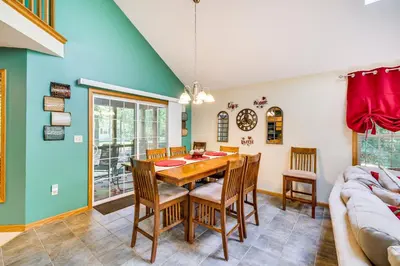 a dining room with a table and chairs and a couch at Deck and Screened Porch Pocono Lake Vacation Rental in Pocono Lake