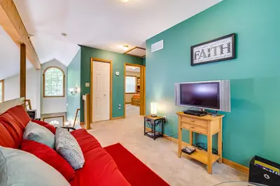 a living room with a red couch and a flat screen tv at Deck and Screened Porch Pocono Lake Vacation Rental in Pocono Lake