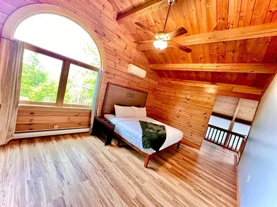 a bedroom with a bed in a wooden room at Big Bear Cabin in Corning
