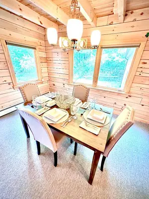 a dining room with a wooden table and chairs at Big Bear Cabin in Corning