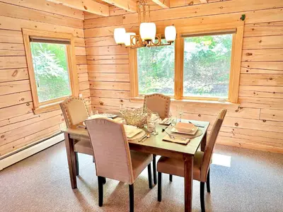 a wooden dining room with a table and chairs at Big Bear Cabin in Corning
