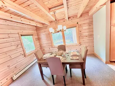 a wooden dining room with a table and chairs at Big Bear Cabin in Corning