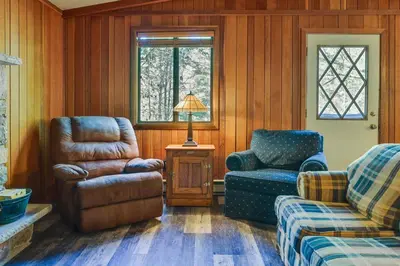a living room with a chair and a couch and a lamp at Gouldsboro Vacation Rental with Pool and Lake Access! in Gouldsboro