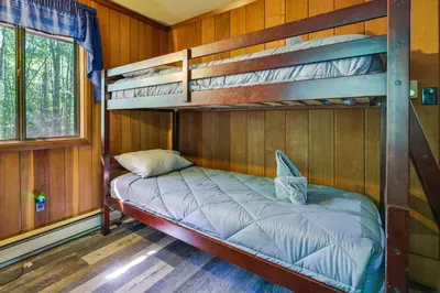 a bedroom with two bunk beds in a cabin at Gouldsboro Vacation Rental with Pool and Lake Access! in Gouldsboro