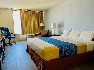 a hotel room with a bed and a desk and a chair at Travelodge by Wyndham Carlisle North in Carlisle