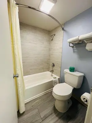a bathroom with a toilet and a tub and a sink at Travelodge by Wyndham Carlisle North in Carlisle