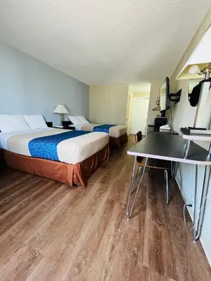 a hotel room with two beds and a desk at Travelodge by Wyndham Carlisle North in Carlisle