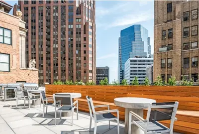 a rooftop patio with tables and chairs and a city skyline at FiDi Studio w Gym Lounge Complete Gym NYC-499 in New York
