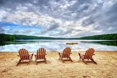 three chairs sitting in the sand on a beach at Serene & Fun Family Gem ~ Big Bass Lake Community! in Gouldsboro