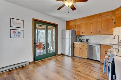 a kitchen with wooden floors and a ceiling fan at Serene & Fun Family Gem ~ Big Bass Lake Community! in Gouldsboro