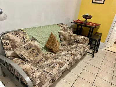 a couch sitting in a living room next to a table at Full bed studio near Temple and Center city Philadelphia in Philadelphia