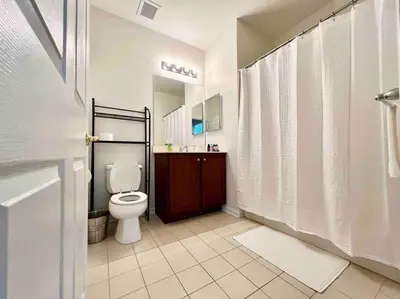 a bathroom with a toilet and a sink and a shower at Luxury Condo Near NYC, MetLife & American Dream in Passaic