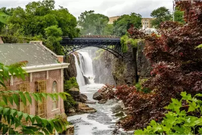 a waterfall under a bridge over a river at Luxury Condo Near NYC, MetLife & American Dream in Passaic