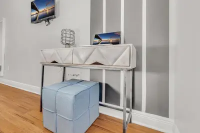 a console table with a blue stool in a room at Fairmount Art Museum Center City Suites in Philadelphia