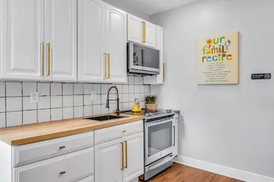 a kitchen with white cabinets and a sink at Fairmount Art Museum Center City Suites in Philadelphia