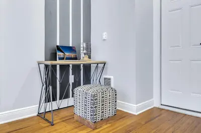 a room with a table and a stool next to a door at Fairmount Art Museum Center City Suites in Philadelphia