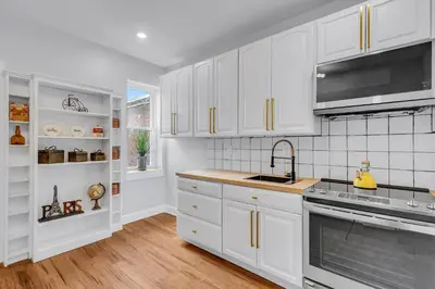 a kitchen with white cabinets and a sink at Fairmount Art Museum Center City Suites in Philadelphia