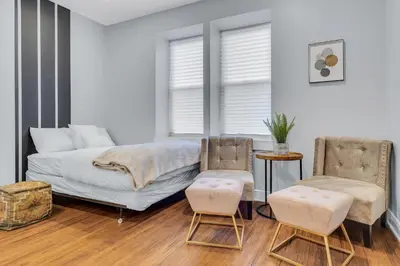 a living room with a bed and two chairs at Fairmount Art Museum Center City Suites in Philadelphia