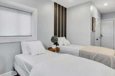 two beds in a room with white walls and a window at Fairmount Art Museum Center City Suites in Philadelphia