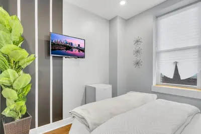 a white room with a tv on a wall at Fairmount Art Museum Center City Suites in Philadelphia