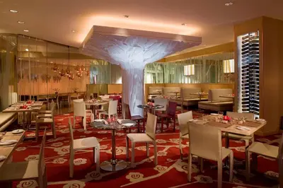 a restaurant with tables and chairs and a large tree at Hyatt Regency New Brunswick in New Brunswick