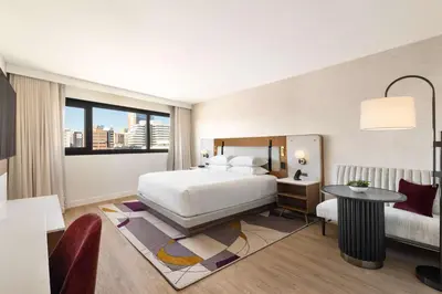 a bedroom with a bed and a desk and a window at Hyatt Regency New Brunswick in New Brunswick