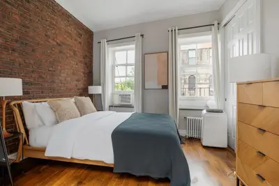 a bedroom with a bed and a brick wall at West Village 1br w high ceilings skylight wd NYC-1172 in New York