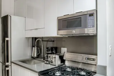 a kitchen with a stove and a microwave at West Village 1br w high ceilings skylight wd NYC-1172 in New York