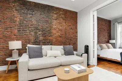 a living room with a couch and a brick wall at West Village 1br w high ceilings skylight wd NYC-1172 in New York