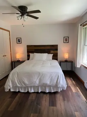 a bedroom with a bed with a ceiling fan at Falls Edge Farm Cottage in Benton