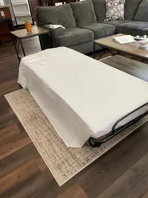 a mattress sitting on a rug in a living room at Falls Edge Farm Cottage in Benton