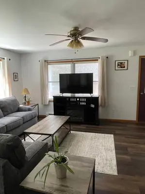 a living room with a couch and a flat screen tv at Falls Edge Farm Cottage in Benton