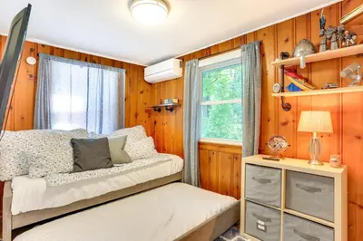 a bedroom with wooden walls and a bed and a window at All-Season Vernon Township Lake House Retreat! in Vernon Township