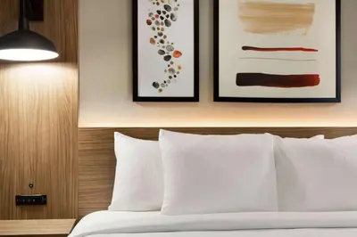 a bedroom with a bed with two pictures on the wall at Hawthorn Extended Stay by Wyndham Mount Laurel Moorestown in Mount Laurel