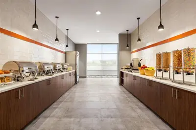 a large kitchen with brown cabinets and some food at Hawthorn Extended Stay by Wyndham Mount Laurel Moorestown in Mount Laurel