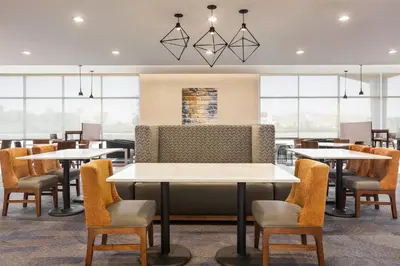 a restaurant with tables and chairs and windows at Hawthorn Extended Stay by Wyndham Mount Laurel Moorestown in Mount Laurel