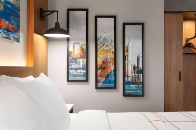 four framed pictures on a wall above a bed at La Quinta Inn & Suites by Wyndham Mount Laurel Moorestown in Mount Laurel